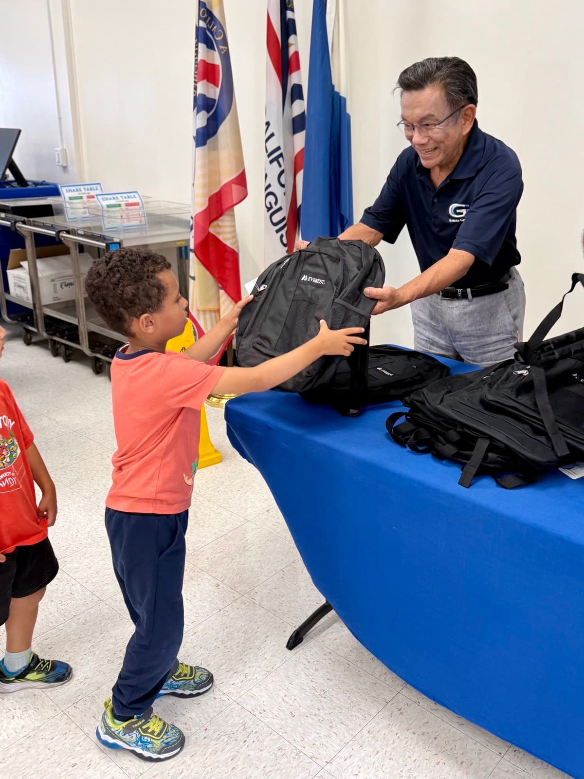 Phat Bui handing out backpacks to local students